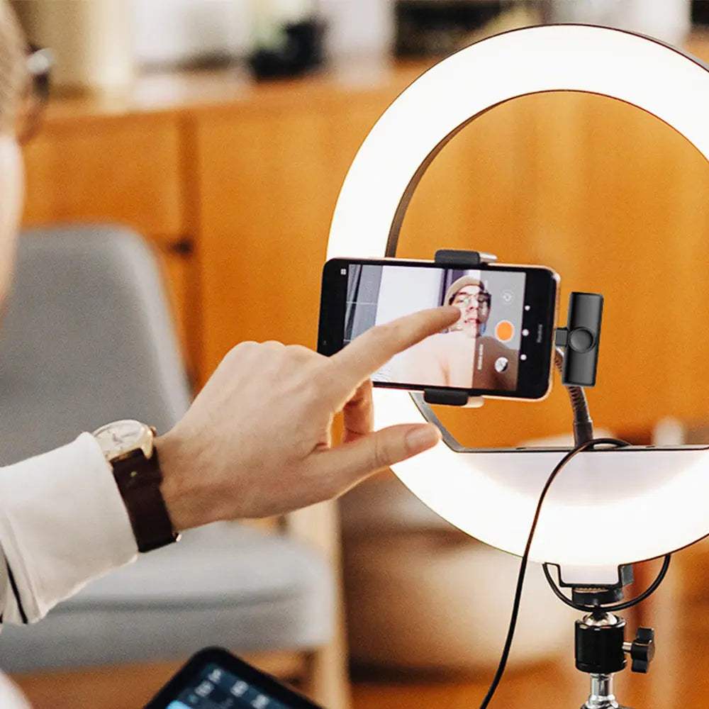 Draadloze microfoon aangesloten op smartphone voor video-opnames en live streaming met ringlamp achtergrond.