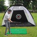 Man practicing golf swing in a black and green golf oefennet tent with target net on outdoor grass field