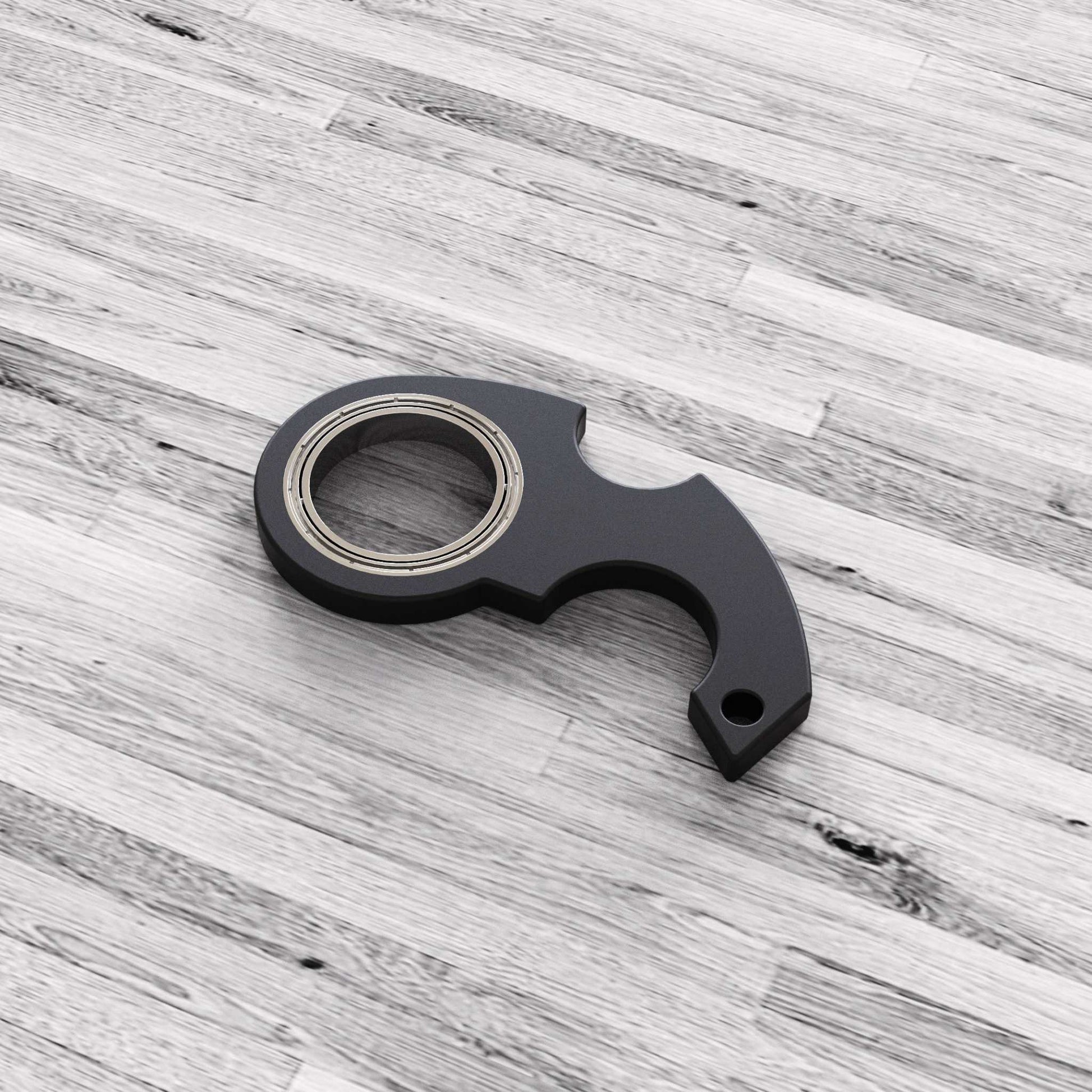Zwarte fidget spinner speelgoed sleutelhanger van kunststof en zinklegering op houten vloer
