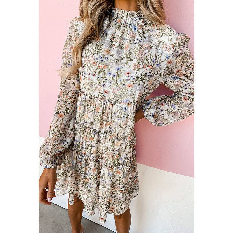 Vrouw draagt losse jurk met hoge taille en bloemenprint voor roze achtergrond