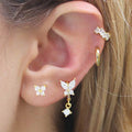 Close-up of ear wearing gold diamond butterfly ear ring and matching earrings set
