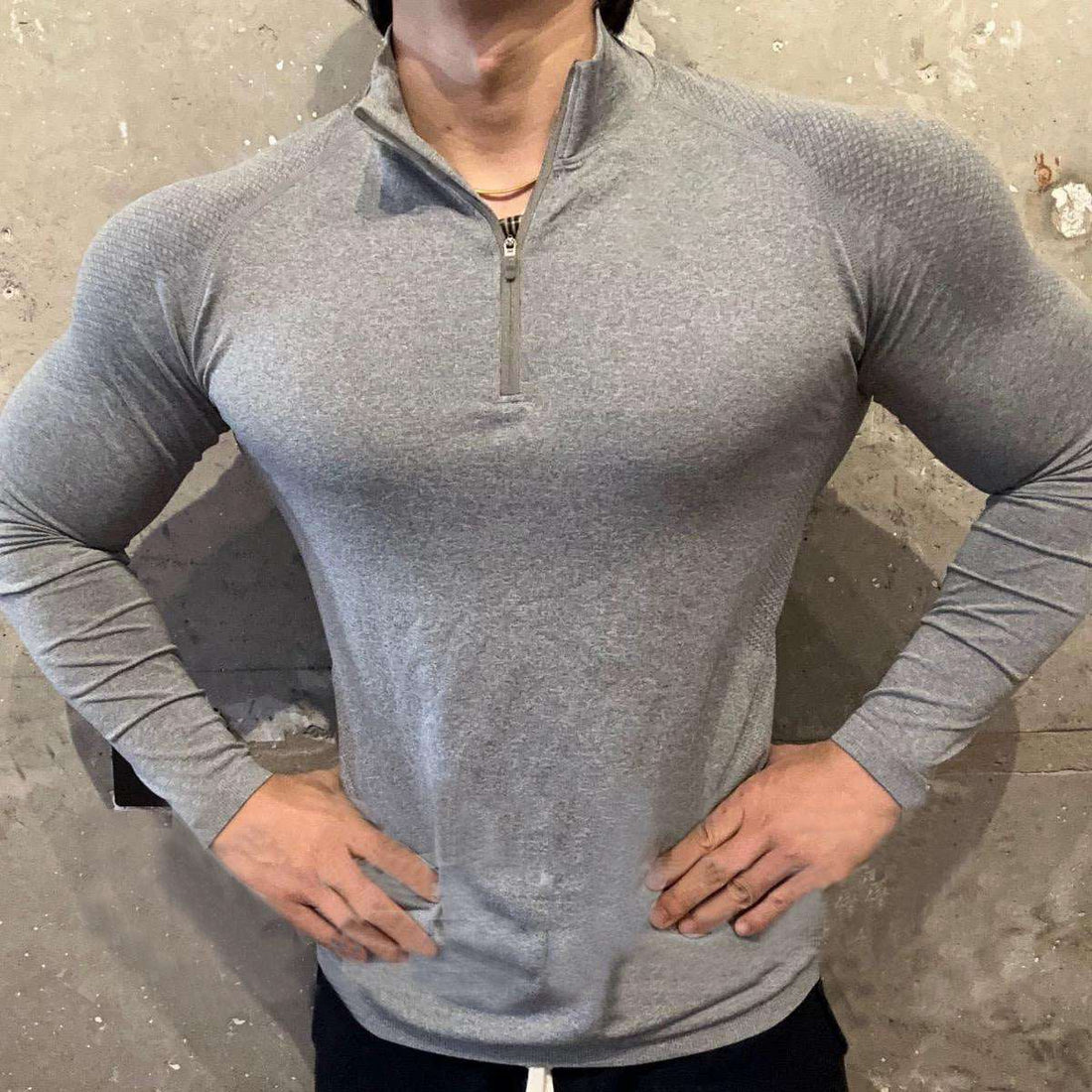 Man in sports gymwear wearing a slim fit grey seamless long sleeve training top with raglan sleeves