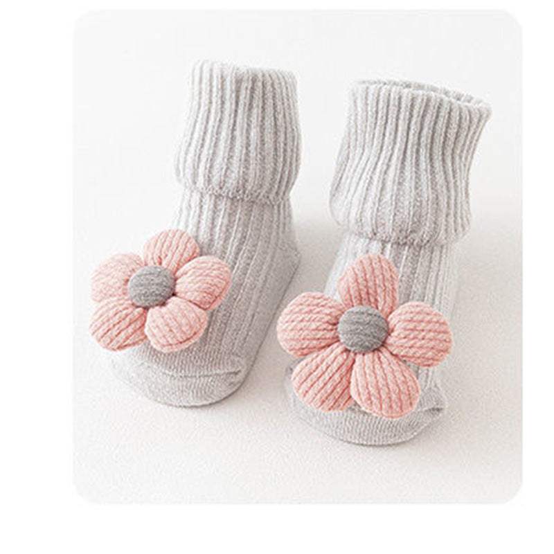 Grey knitted babysokjes with pink flower decoration for infants